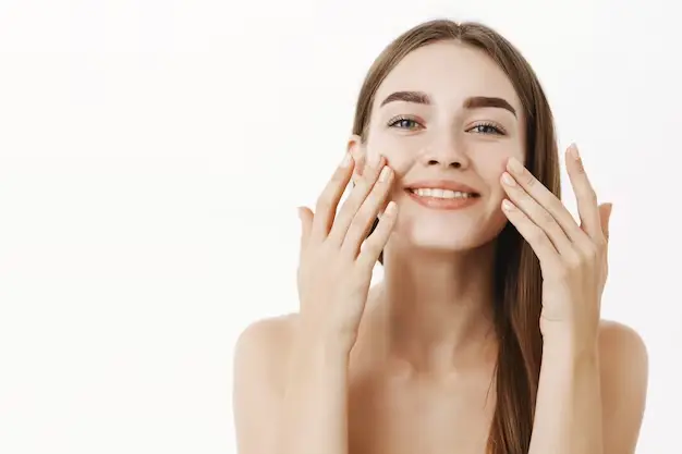 Woman applying natural skincare product for a youthful glow